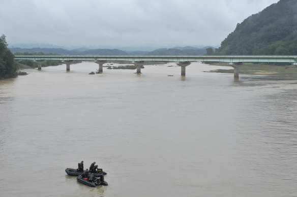 South Korean marines on boats search for missing people in the Sam River in Yecheon.