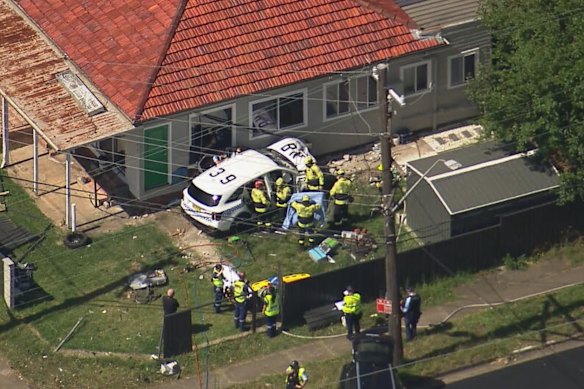 Fire and Rescue NSW work to free an officer trapped in a crashed NSW Police car at Blacktown.