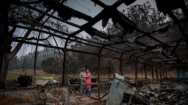 Mark Brooks with his daughter Kylee at his home, which was destroyed by bushfires. 