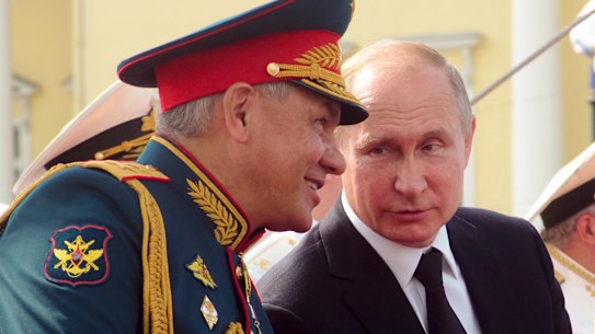Russian Defence Minister Sergei Shoigu speaks to President Vladimir Putin during celebrations in St Petersburg in July.