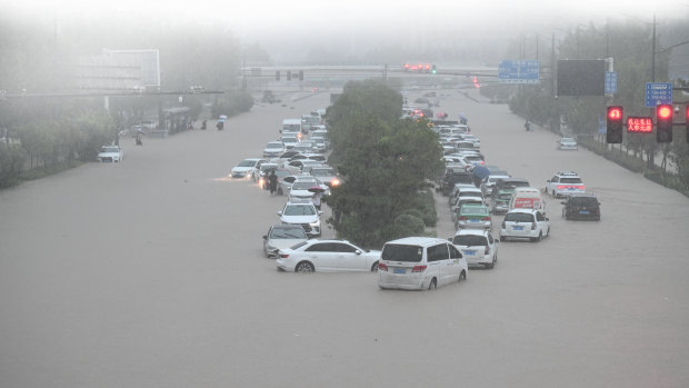 Vehicles are stranded in floodwater near Zhengzhou Railway Station on July 20. Floods in China and Germany have hampered global supply chains.