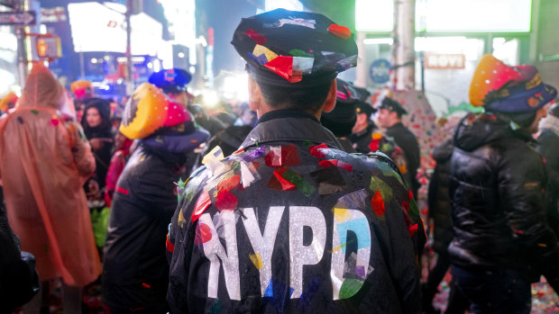 A New York City police officer is covered with confetti.