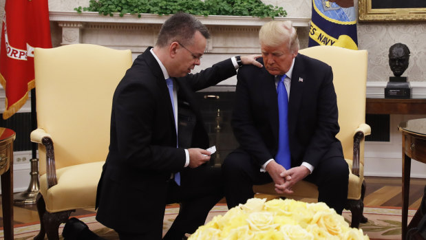 US President Donald Trump prays with American pastor Andrew Brunson in the Oval Office of the White House, on Saturday.