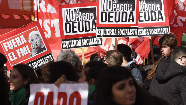 Protesters hold signs that read in Spanish: "Out IMF and No to the payment of the debt" during a demonstration against the IMF near a G20 Finance Ministers meeting in Buenos Aires, Argentina, in July.