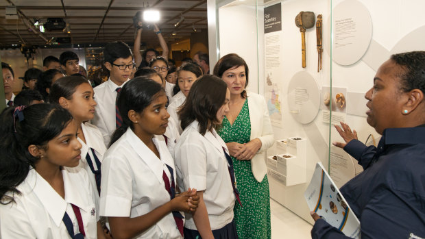 Torres Strait and Pacific curator Imelda Miller with Minister Leeanne Enoch and students, talking about the First Scientists collection in the Queensland Museum Discovery Centre.