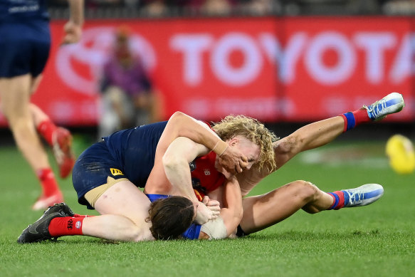 Clayton Oliver of the Demons and Jarrod Berry of the Lions wrestle during the AFL second semi-final. 