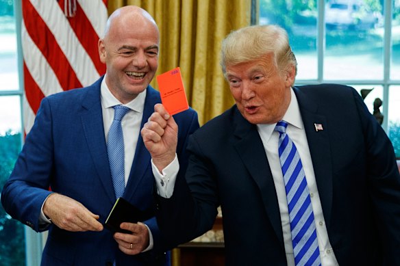 President Donald Trump holds up a red card during a meeting with FIFA president Gianni Infantino in the Oval Office in 2018.
