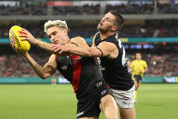 Matt Guelfi of the Bombers is challenged by Blues defender Nic Newman.