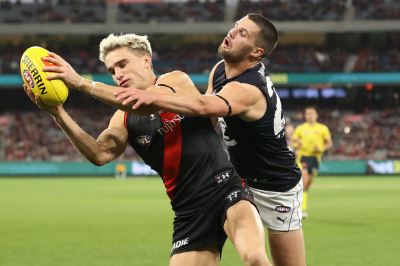 Matt Guelfi of the Bombers is challenged by Blues defender Nic Newman.