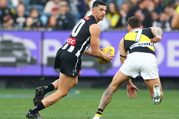 Scott Pendlebury of the Magpies runs with the ball.