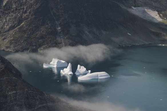 Icebergs are seen through a window of an airplane carrying NASA scientists as they fly on a mission to track melting ice in eastern Greenland.