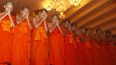 Members of Wild Boars soccer team pray during a ceremony marking the completion of their serving as novice Buddhist monks.