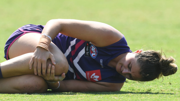 Alex Williams of the Dockers nurses her knee on the ground.