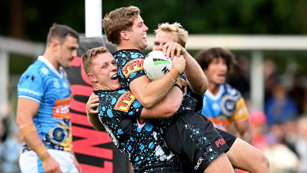 Blayke Brailey scores for the Sharks and is mobbed by teammates at Coffs International Stadium.