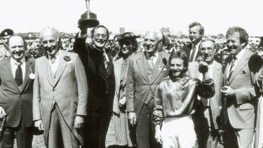 Lloyd Williams holds his first Melbourne Cup, won by Just  A Dash, trained by Tommy Smith, left, and ridden by Peter Cook.