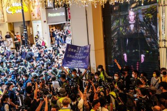 防暴警察在香港一家购物中心内举起蓝旗，警告人们在抗议期间不要分散。 