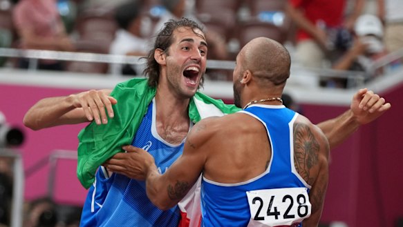 High jump gold medalist Gianmarco Tamberi, left, congratulates compatriot Lamont Marcell Jacobs.
