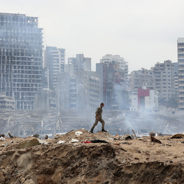 A soldier walks past the crater left by the devastating explosion at the Port of Beirut. 