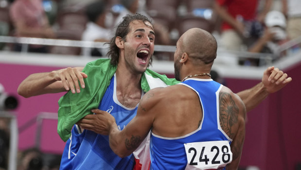 High jump gold medalist Gianmarco Tamberi, left, congratulates compatriot Lamont Marcell Jacobs.