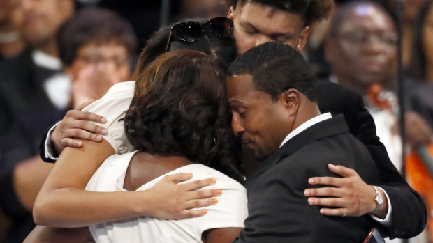 Family members, including Franklin's grandchildren and niece, hug after speaking at the funeral service.