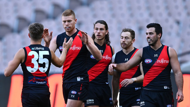 Peter Wright of the Bombers is congratulated by his teammates.