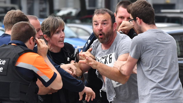 Police trying to calm a man at the scene of the shooting.