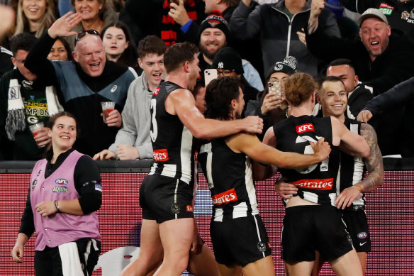 Collingwood players swamp Jamie Elliott after his goal.