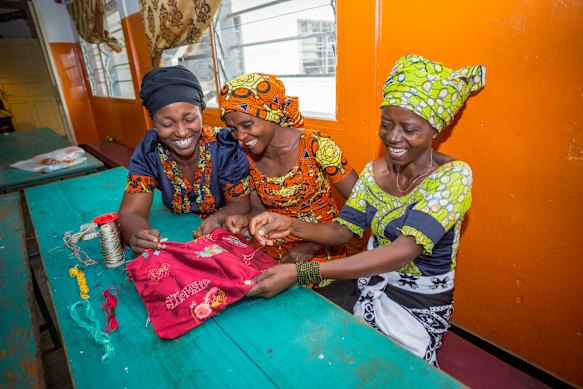 Democratic Republic of Congo artists Gisele, Esther and Esperance work on dresses in 2018.