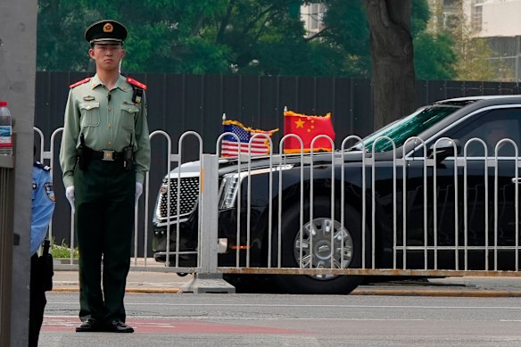 A Chinese paramilitary policeman stands guard as Trump’s limousine approaches.