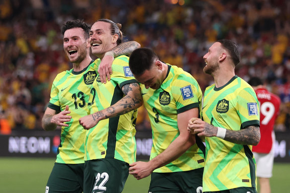 Jackson Irvine celebrates with Australian teammates.