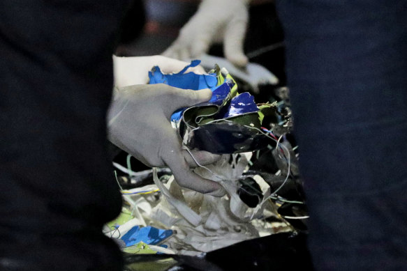 Rescuers examine debris found in the water off Java Island. 