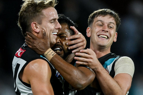 Willie Rioli is hugged by Jackson Mead and Zak Butters.