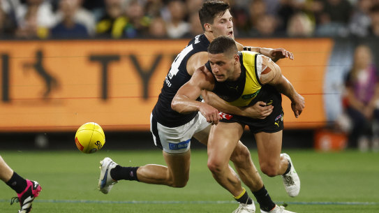 Tim Taranto of the Tigers is tackled by Nic Newman of the Blues.