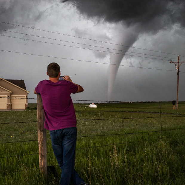 A Wyoming local watches a tornado meander through an estate west of the state capital Cheyenne.