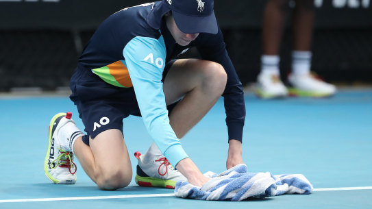 A ball kid dries a court at Melbourne Park.