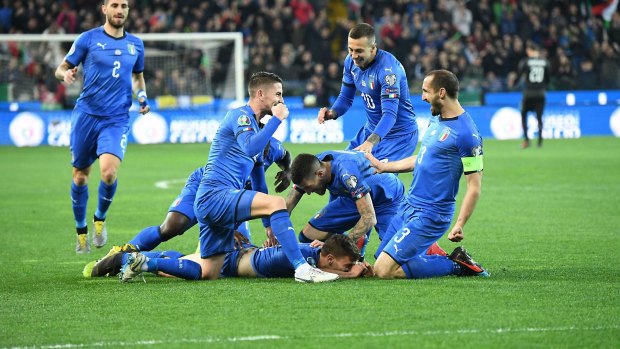 Italy's Nicolo Barella, on the ground, celebrates with his teammates after scoring against Finland.