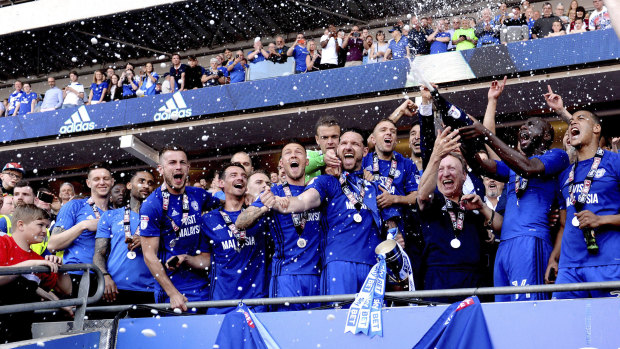 Promotion master: Neil Warnock and the Cardiff squad celebrate going up.