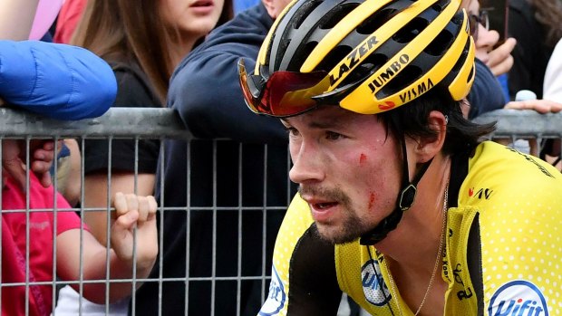 A battered Primoz Roglic reaches the finish line of stage 15, after crashing.