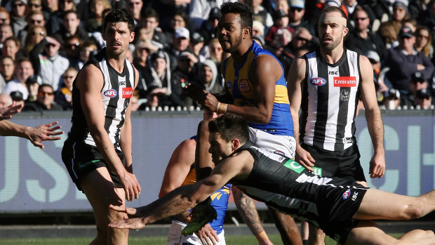 Flying smother: West Coast's Willie Rioli goals through a Collingwood pack.
