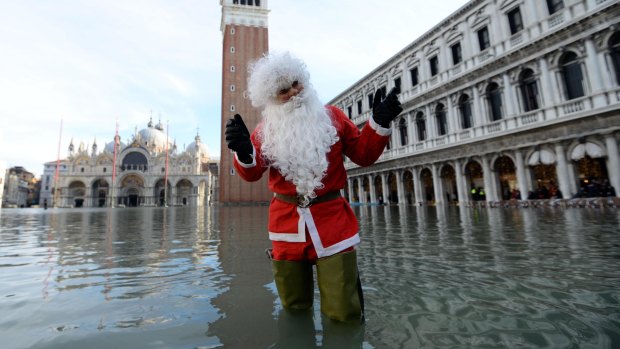 A man dressed as Santa Claus poses in St Mark's Square in Venice, Italy, during a high tide of 1.44 metres on Monday.