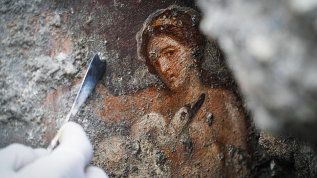 An archaeologist works on the fresco ''Leda e il cigno'' (Leda and the swan) recently discovered in the Regio V archeological area in Pompeii.