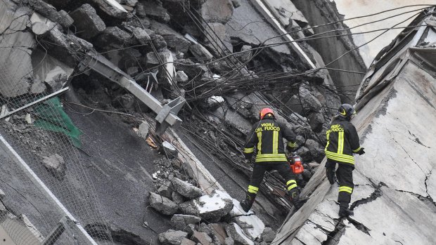 Rescuers work among the rubble of the collapsed bridge in Genoa.