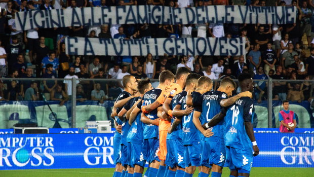 Respect: Empoli players come together and supporters show a banner in memory of the victims of the bridge collapse.