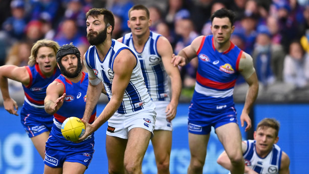 Luke McDonald of the Kangaroos handballs.