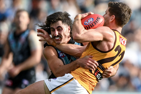 Luke Breust of the Hawks is tackled by Lachie Jones.