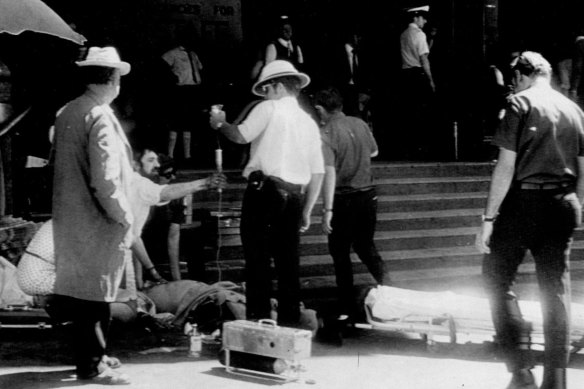 A doctor and paramedics try to save Senior Constable Norm Curson’s life as he lies at the steps of Flinders Street Station.