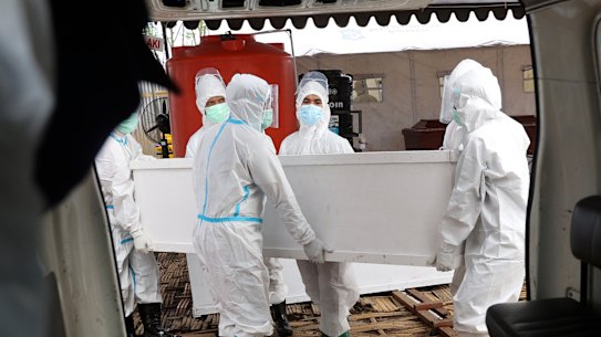 Health workers carry a coffin containing the body of a COVID-19 victim in East Java, Indonesia in July.