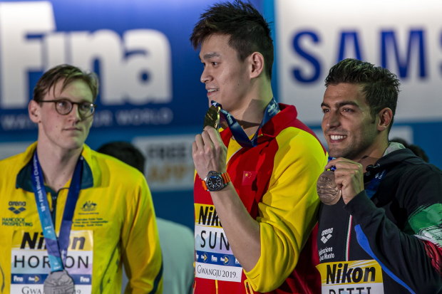 Mack Horton (left) makes his point as Sun Yang (centre) accepts his gold medal at the 2019 world championships.