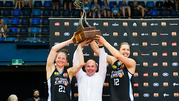 Kelsey Griffin, coach Paul Goriss and Marianna Tolo hold the grand final trophy.