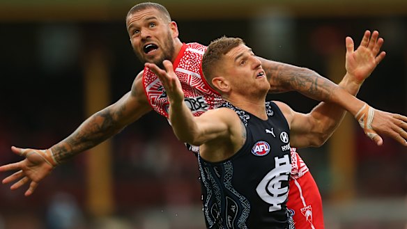 Lance Franklin battles Jacob Weitering of the Blues for possession. 
